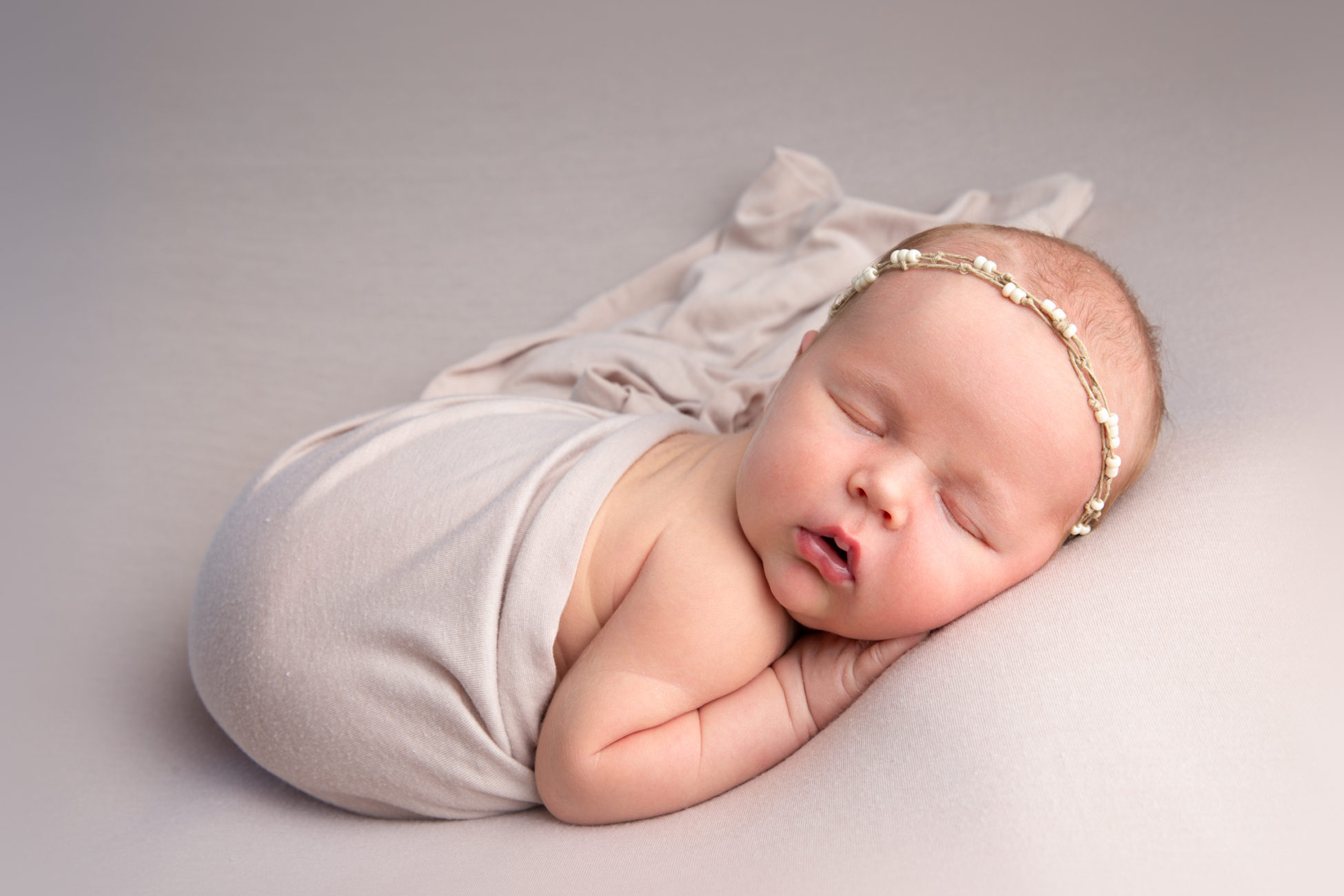 sleeping newborn baby posed on bean bag